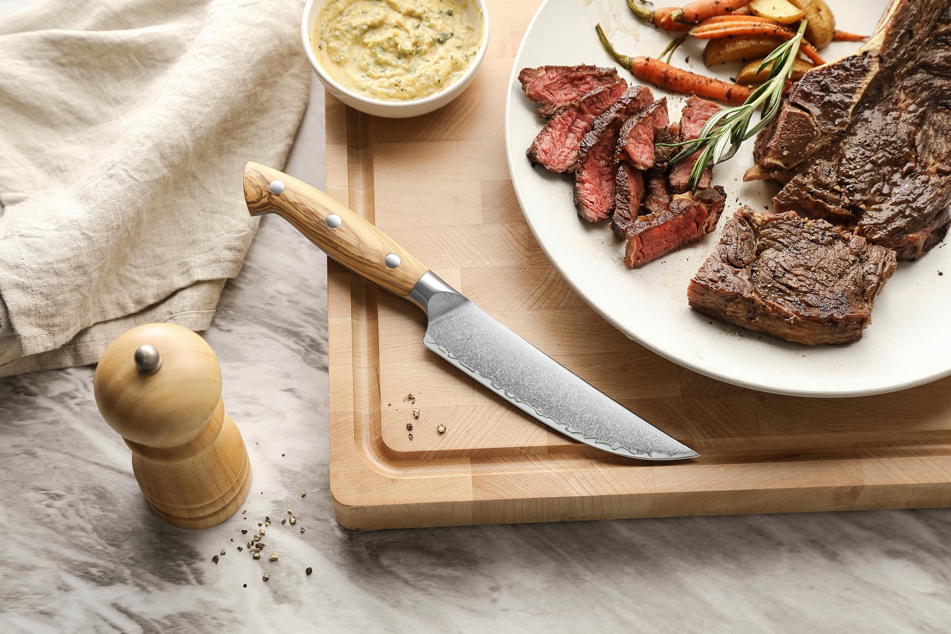 Steakový nůž XinZuo Pin X02O položený na prkénku