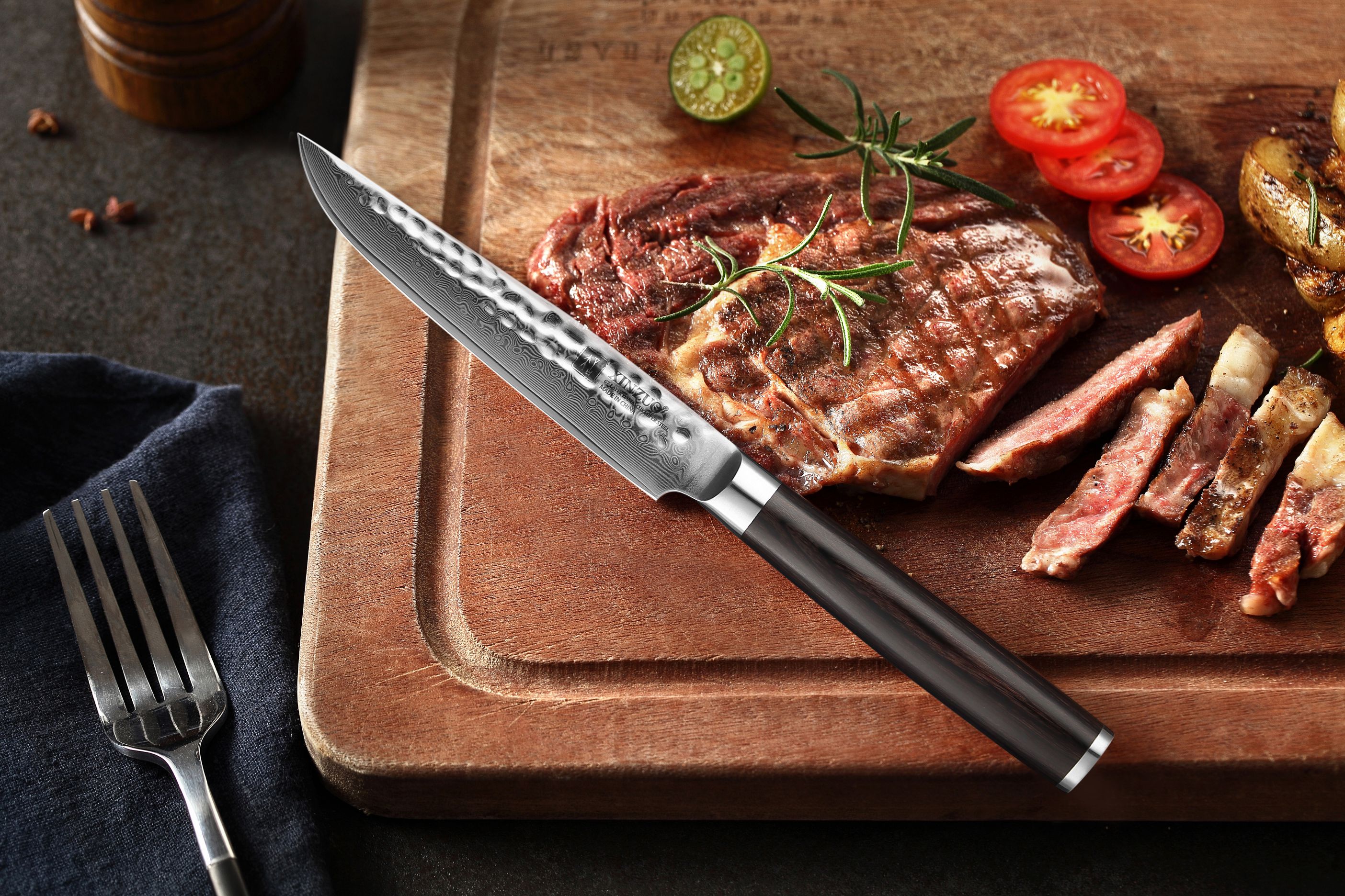 Steakový nůž XinZuo  He B1H položený vedle steaku